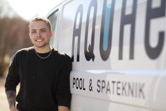 Spabadsteknikern Filip Baudin från Aquae Pool & Spateknik står framför en av Aquaes företagsbilar.